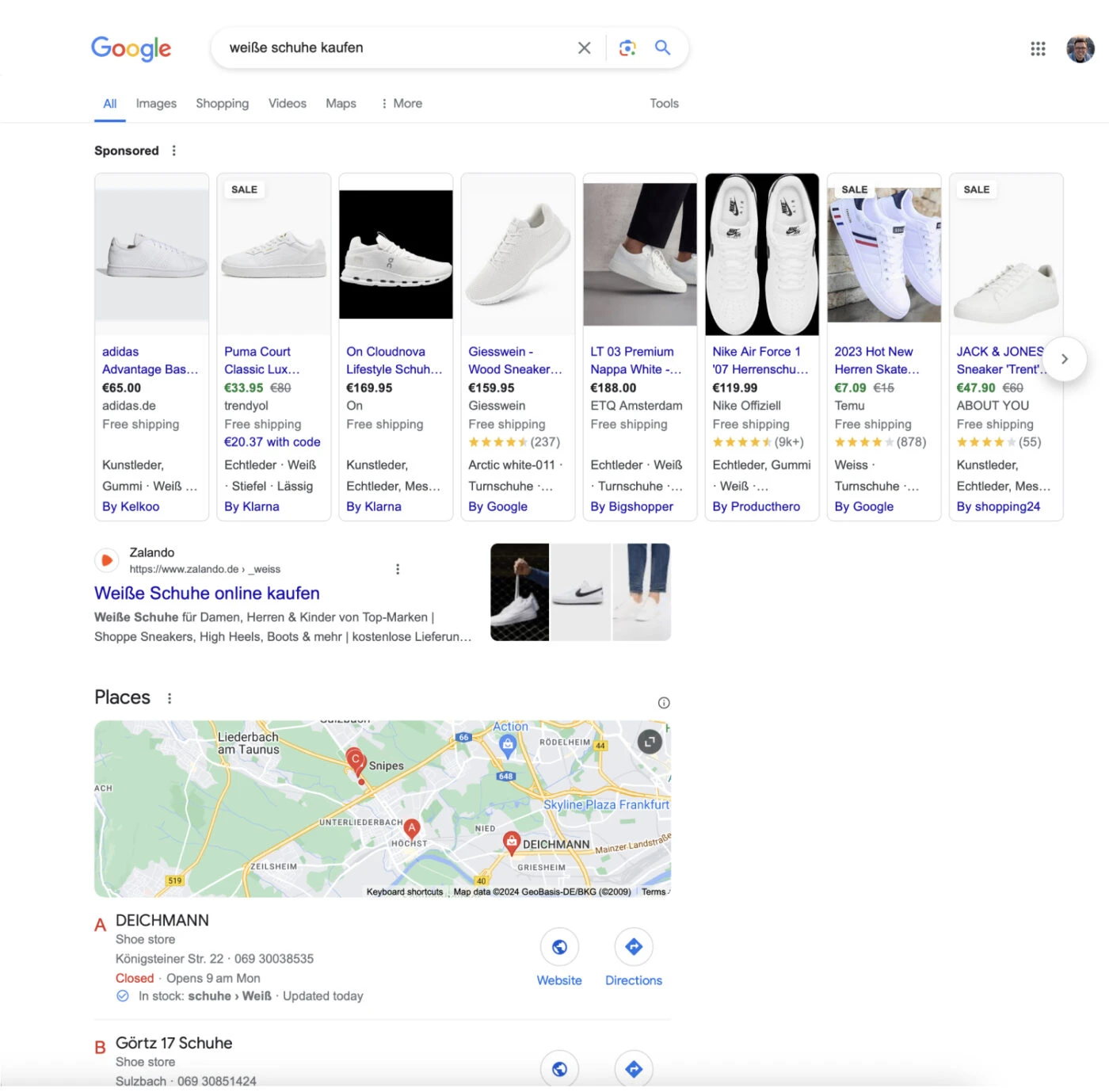 Das Bild zeigt eine Google-Suchergebnisseite (SERP) für die Anfrage "weiße schuhe kaufen". Oben befinden sich gesponserte Anzeigen mit verschiedenen weißen Schuhen von Marken wie Adidas, Puma und Nike, die Preise und Verkäufer anzeigen. Darunter befindet sich ein organisches Suchergebnis von Zalando mit einem Link und einer Beschreibung.